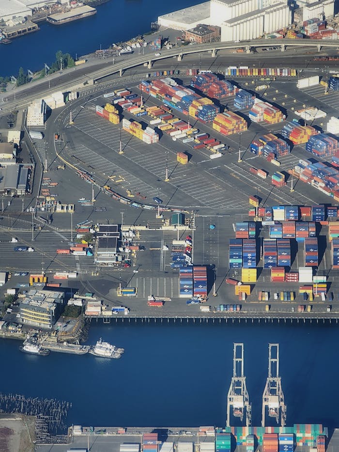 Overhead view of a bustling port with colorful shipping containers and waterfront area.